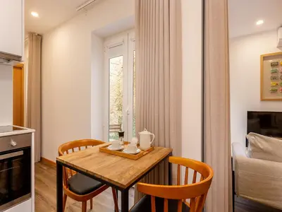 a small dining room with a wooden table and chairs at Charming 1-Bedroom Apartment in Oporto in Porto