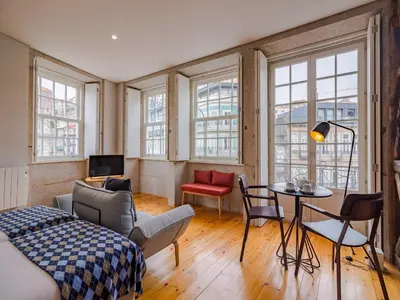 a room with a bed and a table and chairs at Pretty apartment with modern comforts in Porto