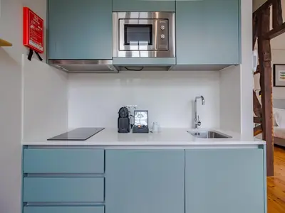 a kitchen with a sink and a microwave at Pretty apartment with modern comforts in Porto