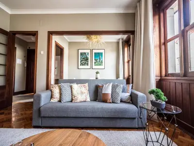 a living room with a blue couch with pillows at Spacious 4-Bedroom Apartment in Porto in Porto