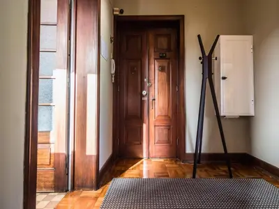 an empty room with a wooden door and a rug at Spacious 4-Bedroom Apartment in Porto in Porto