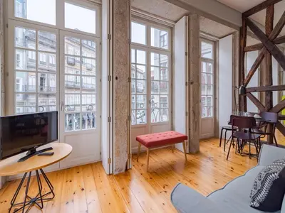 an apartment with large windows and a living room at Charming studio in the heart of Porto in Porto