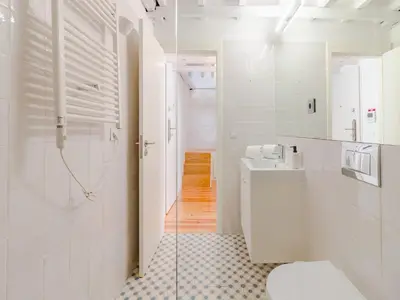 a white bathroom with a toilet and a sink at Central Porto with comfort & convenience in Porto