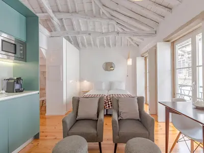 a room with a bed and two chairs and a table at Central Porto with comfort & convenience in Porto