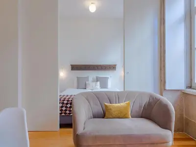 a living room with a couch in front of a bed at Stylish Porto studio with city views in Porto