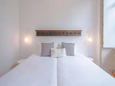 a bedroom with a white bed with two pillows at Stylish Porto studio with city views in Porto