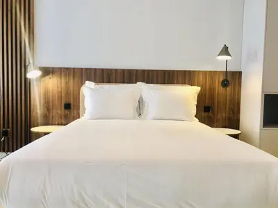 a large white bed with white sheets and pillows at Convenient apartment in the heart of Porto in Porto