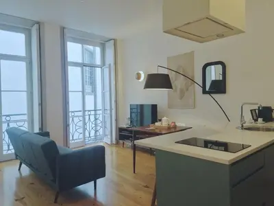 a kitchen with a sink and a chair in a room at Quaint studio in the heart of Porto in Porto