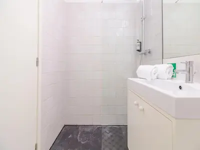 a white bathroom with a sink and a shower at Quaint studio in the heart of Porto in Porto