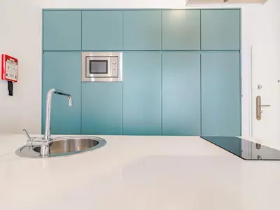 a kitchen with a sink and blue cabinets at Quaint studio in the heart of Porto in Porto