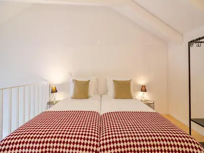 a bed with a red and white checkered blanket at Charming Porto apartment in prime location in Porto