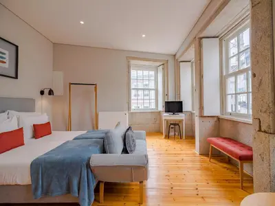 a large bedroom with a bed and a couch at City-center apartment with modern comforts in Porto