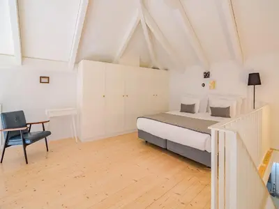 a bedroom with a bed and a desk and a chair at Charming apartment with convenient city access in Porto