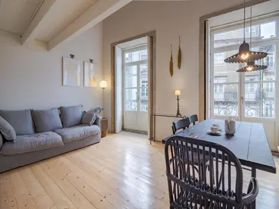 a living room with a table and a couch at Charming apartment with convenient city access in Porto