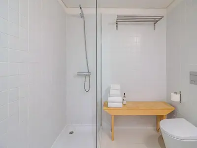 a white bathroom with a shower and a toilet at Charming apartment with convenient city access in Porto