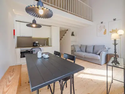 a living room with a table and a couch at Charming apartment with convenient city access in Porto