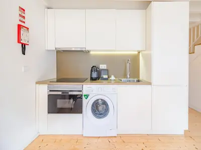 a kitchen with a washing machine and a sink at Charming apartment with convenient city access in Porto