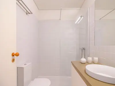 a white bathroom with a sink and a toilet at Charming studio, ideal for smaller groups in Porto