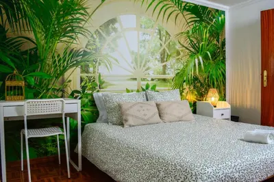 a bedroom with a white bed with orange pillows and a desk at Live Oporto Rooms in Porto
