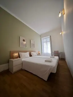 a bedroom with a large white bed and a window at GuestHouse Bragas Porto Center in Porto