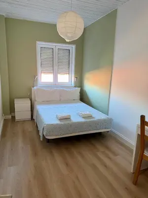 a bedroom with a bed and a window at GuestHouse Bragas Porto Center in Porto