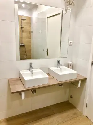 a bathroom with two sinks and a mirror at GuestHouse Bragas Porto Center in Porto