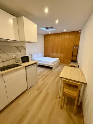 a room with a kitchen and a bedroom with a bed at GuestHouse Bragas Porto Center in Porto