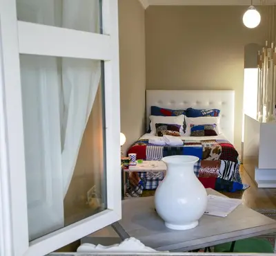 a white vase sitting on a table in front of a bedroom at Cedofeita Village in Porto