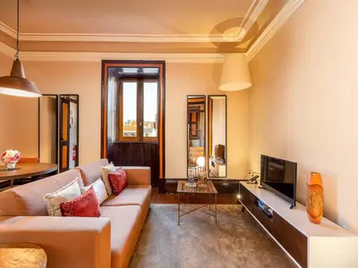 a living room with a couch and a tv at Central Porto Stay with Balcony in Porto