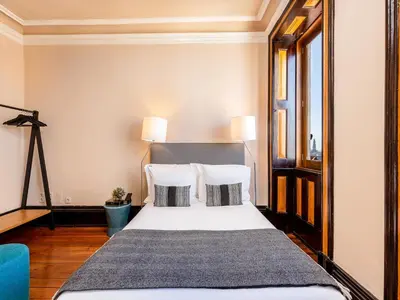 a bedroom with a bed with white sheets and pillows at Cozy Studio in Porto with Modern Amenities in Porto