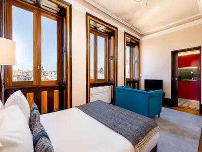 a bedroom with a bed and a blue chair at Cozy Studio in Porto with Modern Amenities in Porto