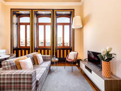 a living room with a couch and a tv at Charming Apartment in Porto's Heart in Porto