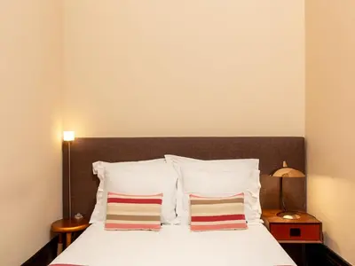a bedroom with a bed with white sheets and pillows at Charming Apartment in Porto's Heart in Porto