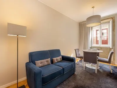 a living room with a blue couch and a table at Porto Pet-Friendly Stay in Porto