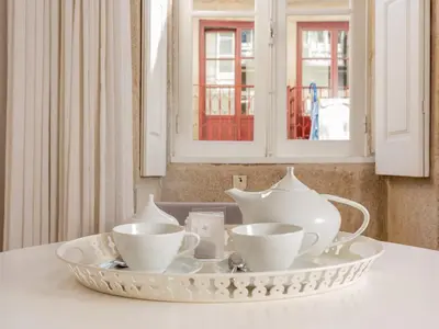 a table with a plate with tea cups on it at Porto Pet-Friendly Stay in Porto