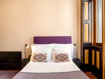 a bedroom with a bed with white sheets and pillows at Charming Porto Studio Central & Cozy in Porto