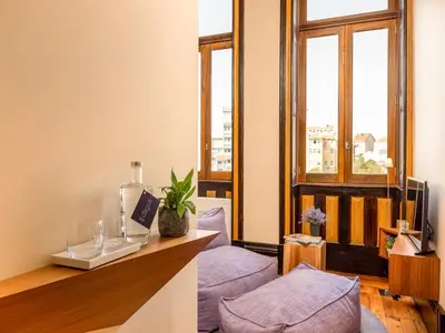 a room with a counter with purple pillows and a window at Charming Porto Studio Central & Cozy in Porto