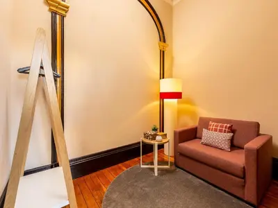 a living room with a chair and a lamp at Chic Porto Studio Cozy & Central Escape in Porto