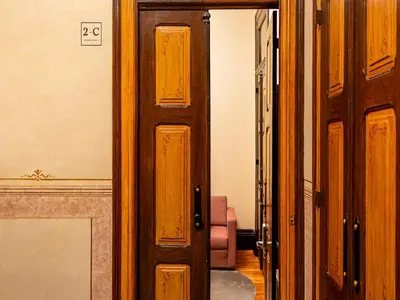 an open wooden door in a room with a couch at Chic Porto Studio Cozy & Central Escape in Porto