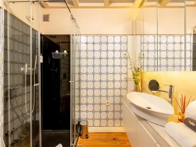 a bathroom with a sink and a glass shower at Chic Porto Studio Cozy & Central Escape in Porto