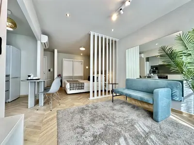 a living room with a blue couch and a bedroom at Compact & Cozy Retreat in Porto s Heart in Porto