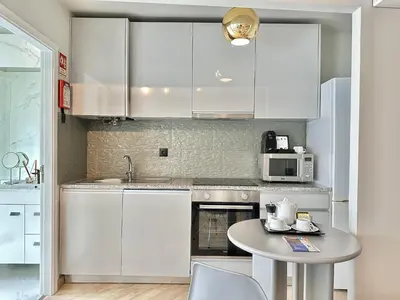 a kitchen with white cabinets and a small table at Compact & Cozy Retreat in Porto s Heart in Porto