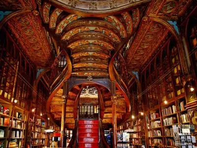 a library with a large ceiling with bookshelves at Duplex 2 Bedroom Apt for 3 in Bolhão Market in Porto