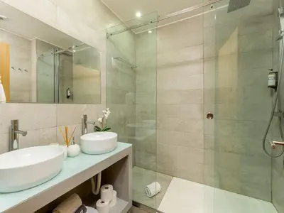a bathroom with a sink and a glass shower at Modern & Cozy apartment, by the beach in Vila Nova de Gaia