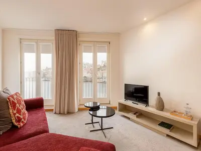 a living room with a red couch and a tv at Modern & Cozy apartment, by the beach in Vila Nova de Gaia