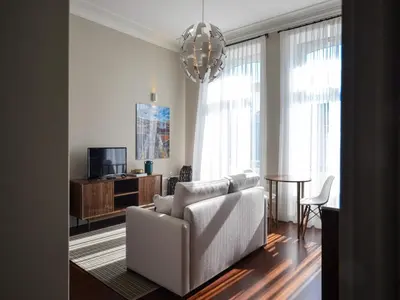 a living room with a white couch and a tv at Cozy 1-bedroom apartment in Porto in Porto