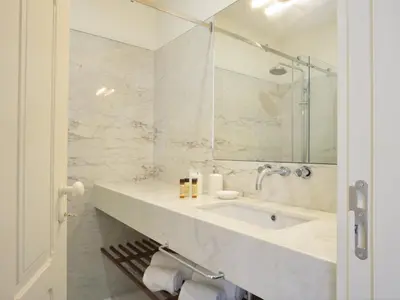 a white bathroom with a sink and a mirror at Cozy 1-bedroom apartment in Porto in Porto