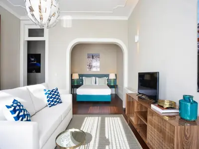 a living room with a bed and a white couch at Cozy 1-bedroom apartment in Porto in Porto