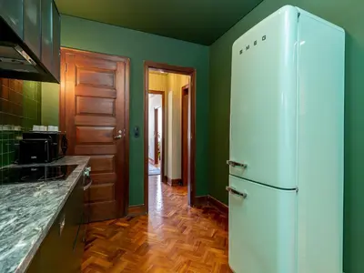 a kitchen with green walls and a white refrigerator at Spacious family apartment in Porto in Porto