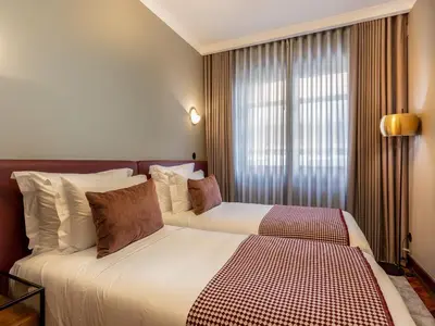 a hotel room with two beds and a window at Spacious family apartment in Porto in Porto